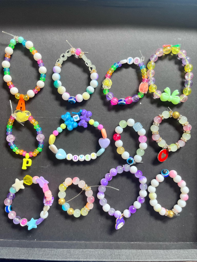 Colourful beaded bracelets with charms on a dark background