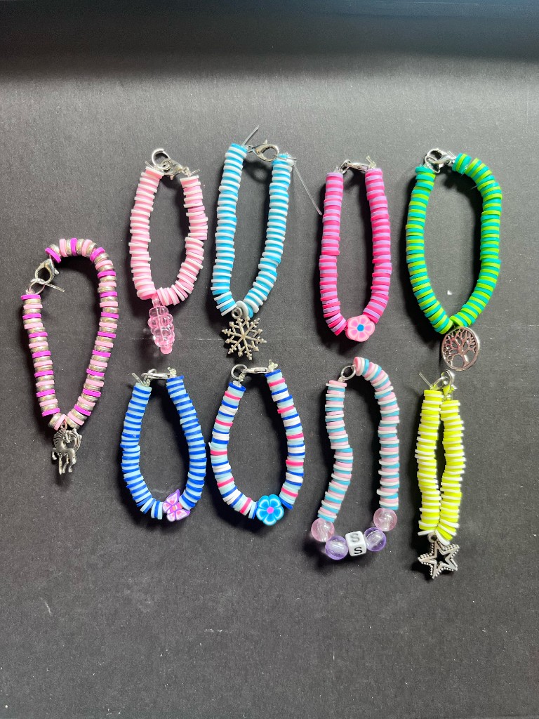 Heishi bead bracelets in pastel colours on a dark background