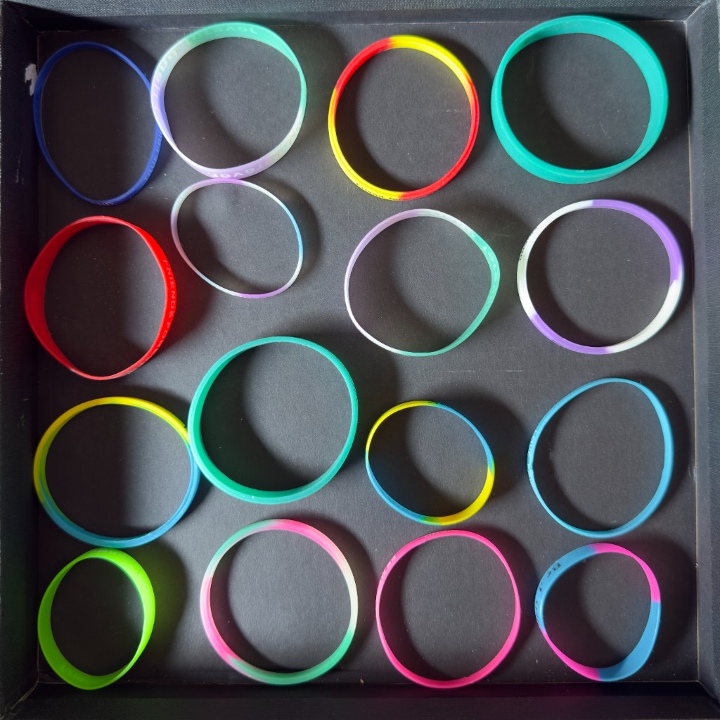 Colourful silicone wristbands in a dark tray